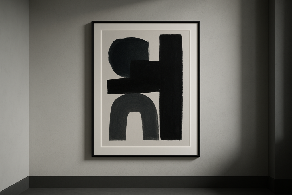 Minimalist abstract wall art with black geometric shapes in a frame on a neutral interior wall